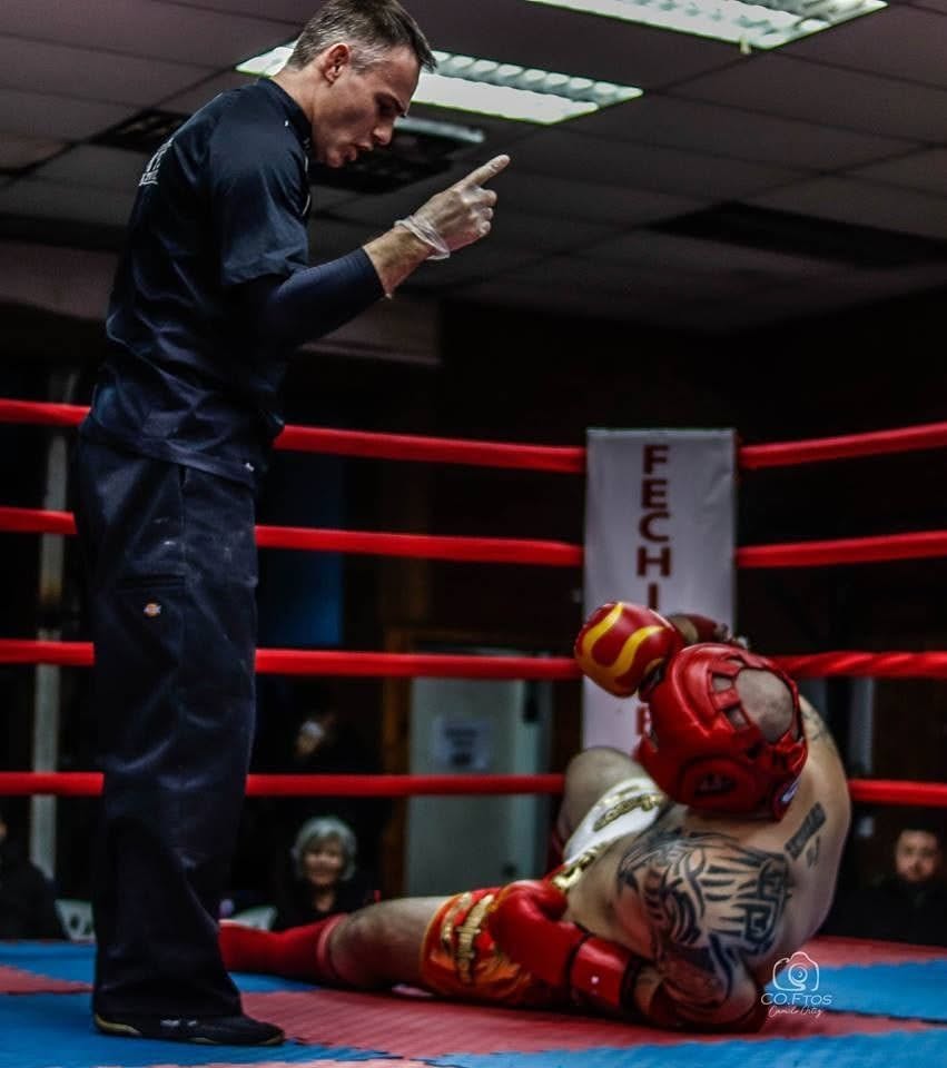 Árbitro realizando cuenta regresiva a competidor caído tras nocaut en el ring